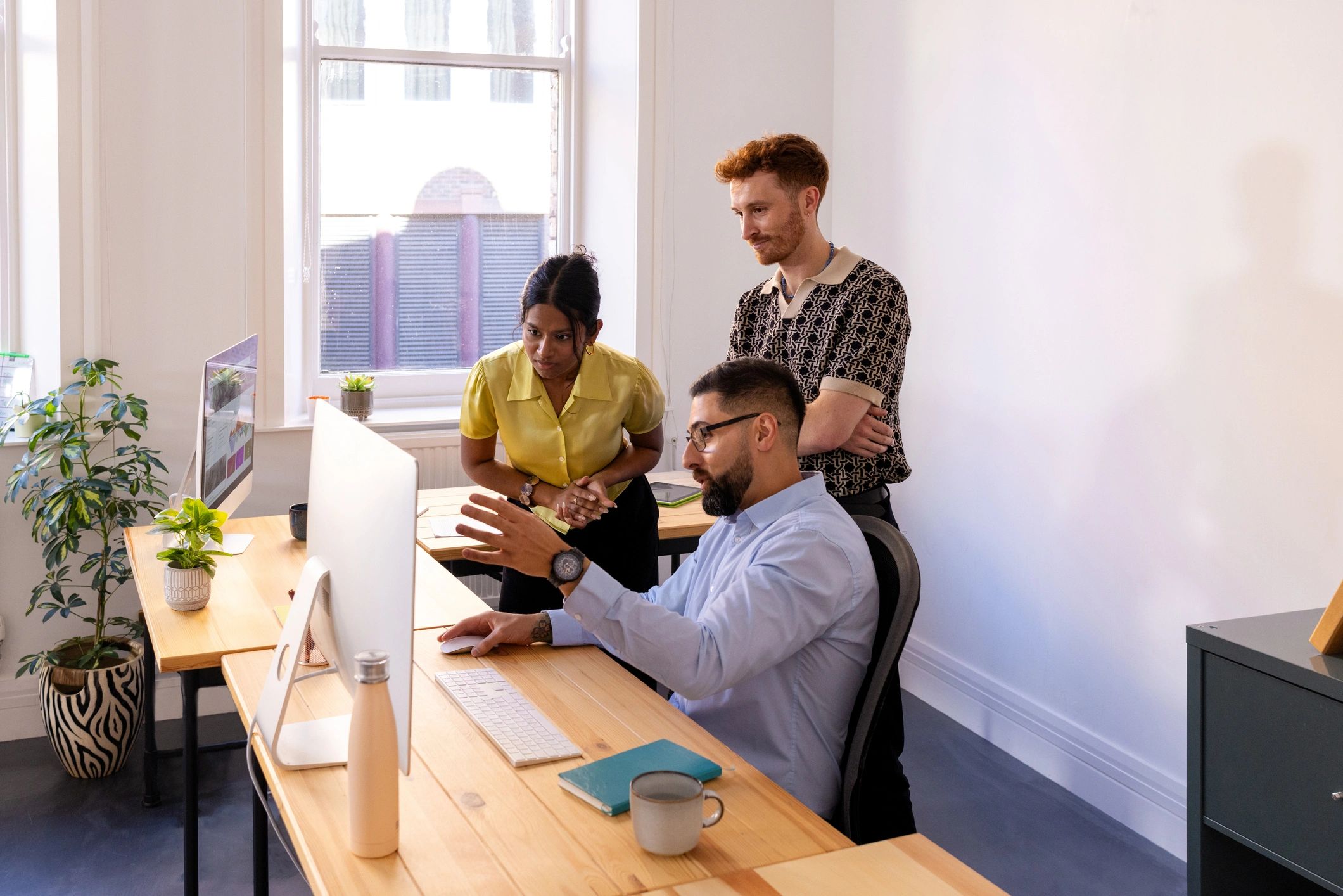 Business team collaborating around a computer