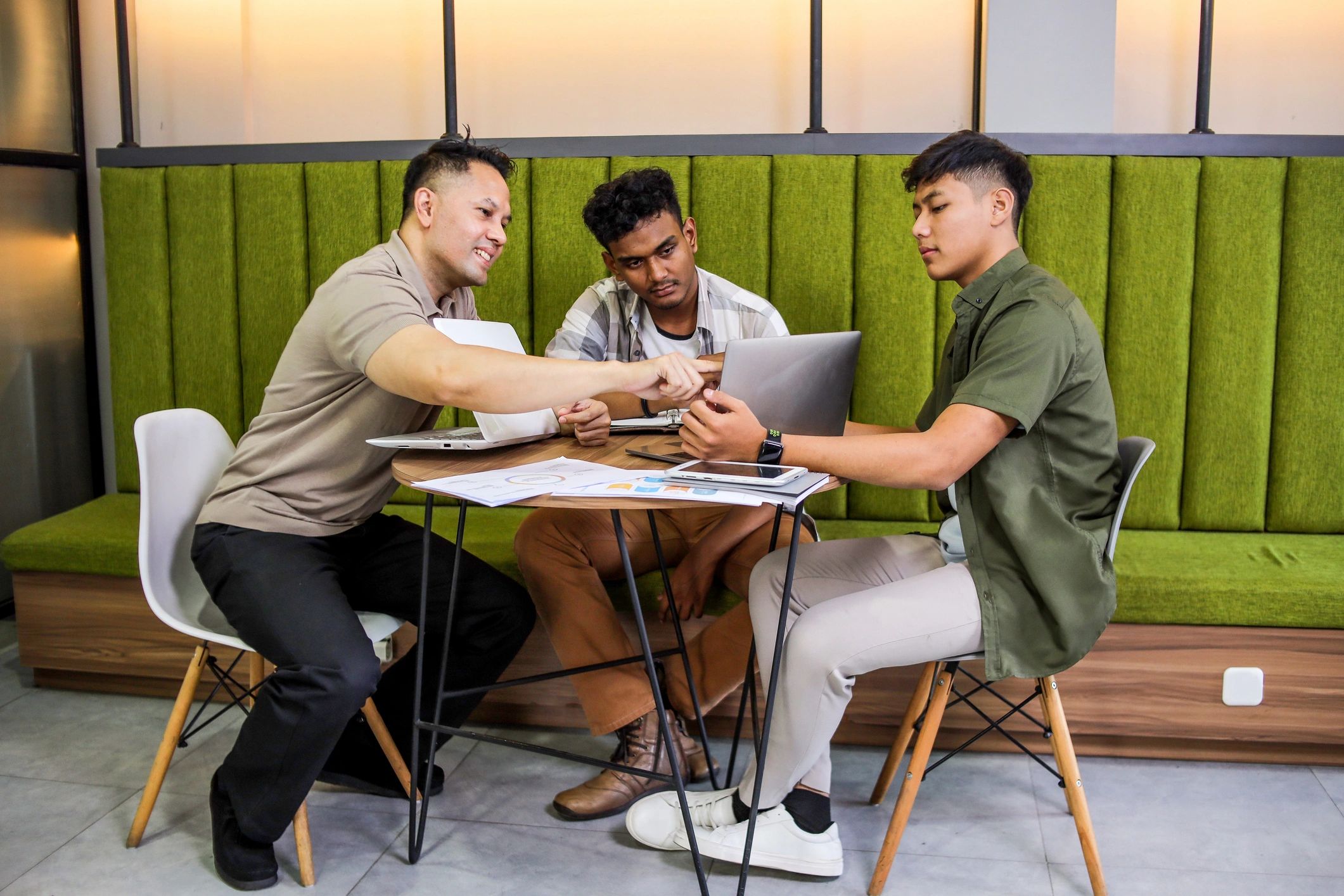 Team members collaborating around a laptop